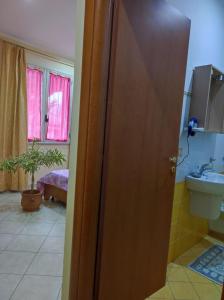 een badkamer met een wastafel, een toilet en een deur bij TropeaCharmet PARKING FREE in Tropea