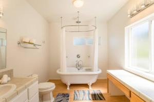 baño blanco con bañera, aseo y lavamanos en Cozy Oceanview! Hot Tub! Oceanfront! Shelter Cove, CA Tesla EV station, en Shelter Cove