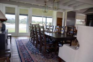 a dining room with a wooden table and chairs at Finsbury House - Luxury 8 Bedroom Farm Homestead with Pool in Kilmore