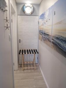 a hallway with a bench and paintings on the wall at Ocean room @ 66 Fynbos in Mossel Bay