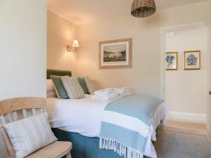 a bedroom with a bed and a chair at Seascape in Salcombe