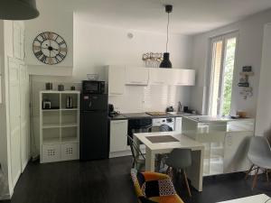 a kitchen with a black refrigerator and a table with chairs at Chez angy et manu in Marseille