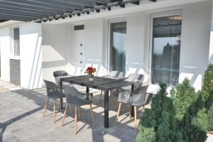 eine Terrasse mit einem Tisch und Stühlen auf einer Terrasse in der Unterkunft Silver Home Apartman "A" in Balatonalmádi
