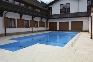a large swimming pool with blue water in a building at Hotel Zajazd Piastowski in Kazimierz Dolny