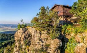 uma casa sentada no topo de uma montanha em Dusznickie Domki Całoroczne em Duszniki Zdrój