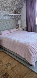 1 dormitorio con 1 cama con edredón rosa en room to the east en Viimsi