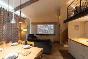 a kitchen and living room with a table and a couch at Appartement moderne 3 chb 3 sdb climatisé in Avignon