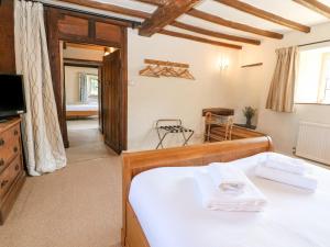 a bedroom with a bed and a tv in a room at Church View Lower Slaughter in Lower Slaughter