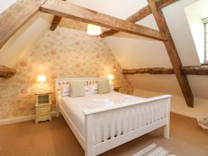 a bedroom with a white bed in a attic at Church View Lower Slaughter in Lower Slaughter