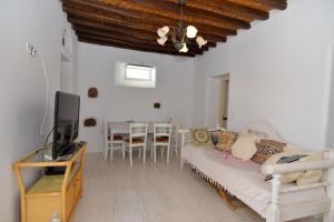 a living room with a couch and a tv at Mykonos 4 bedroom Cycladic home with free parking in Ano Mera