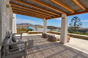 a patio with a wooden roof with a view of the mountains at Mykonos 4 bedroom Cycladic home with free parking in Ano Mera