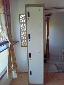 a white cabinet in a room with a window at Dannu's Homestay & Ijen, Bromo, Meru Betiri Sukomade Tours in Banyuwangi