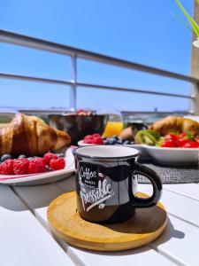 kubek do kawy na drewnianej desce z talerzem jedzenia w obiekcie Luxury apartment Salona w mieście Solin