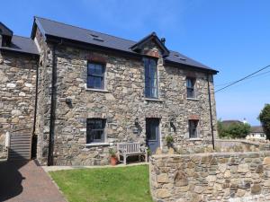 a stone house with a bench in front of it at The Pottery in Newport Pembrokeshire