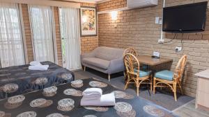 a living room with a table and chairs and a television at Tropicana Motor Inn in Cowes