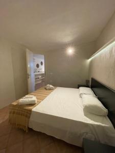 a bedroom with a large bed with white sheets at B H Lampedusa in Lampedusa