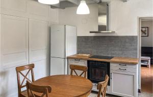 a kitchen with a table and a refrigerator at 2 Bedroom Nice Home In Trambly in Trambly