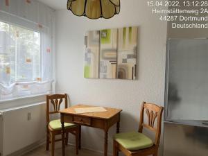 kuchnia ze stołem, krzesłami i lodówką w obiekcie Wohnung im 2 Familienhaus w Dortmundzie