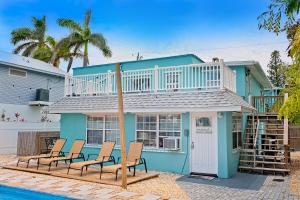 ein blaues Haus mit Stühlen und einem Pool in der Unterkunft Bungalow E in Bradenton Beach