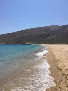 une plage de sable avec l'océan et les montagnes en arrière-plan dans l'établissement Cyclades, villa surplombant la mer, à Ios Chora