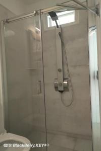 a glass shower door in a bathroom with a toilet at Cyclades, villa surplombant la mer in Ios Chora