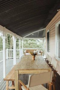 a porch with a wooden table and chairs at Hinterland Luxury Stay - Eastnor in Montville