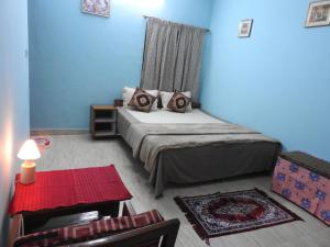 a small bedroom with a bed and a red table at Shanthi Villa in Coonoor