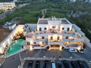an aerial view of a large white house with a parking lot at Hotel Majesty Alberobello in Alberobello