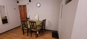 uma mesa de jantar com cadeiras e um relógio na parede em Departamento viña centro em Viña del Mar