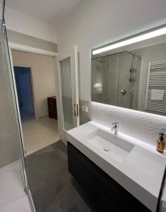 a bathroom with a white sink and a mirror at appartamento Via Antica in Padenghe sul Garda