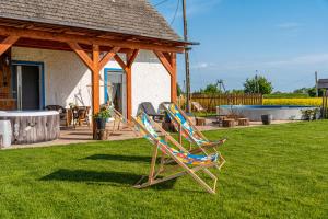 a couple of lawn chairs sitting in a yard at Ranczo Łubowice - wynajmij sobie spokój in Łubowice