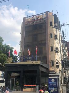 un edificio con bandiere sopra di Hotel Oban a Lahore