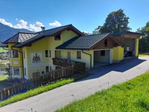 a yellow house with a fence in front of it at Appartement Sonnseitn in Altenmarkt im Pongau