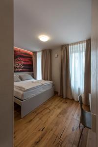a bedroom with a bed and a window and a chair at La Blave Rooms in Mortegliano