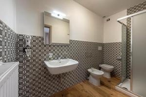 a bathroom with a sink and a toilet and a mirror at La Blave Rooms in Mortegliano