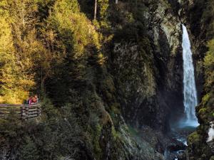 a group of people standing on a bench in front of a waterfall at Beautiful Apartment in Salzburg with Balcony in Bramberg am Wildkogel