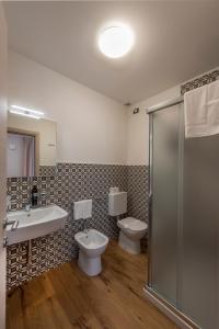 bagno con 2 servizi igienici, lavandino e doccia di La Blave Rooms a Mortegliano