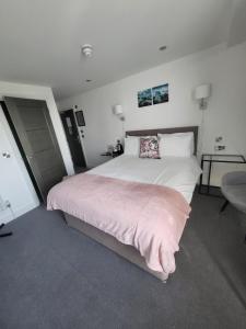 a bedroom with a large bed with a pink blanket at Q8 Boutique Hotel in Portsmouth