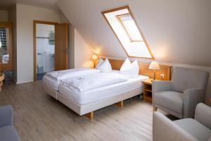 Schlafzimmer mit einem großen Bett und einem Dachfenster in der Unterkunft Gästehaus Kölfhamm 2 in Sankt Peter-Ording