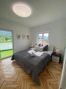 1 dormitorio con cama grande y ventana grande en Apartment MILENA Kaštela mit Whirlpool, en Kaštela