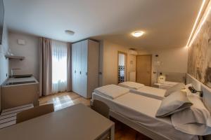 a room with two beds and a table in it at La Blave Rooms in Mortegliano