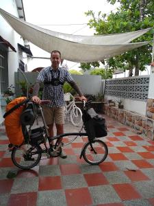 Habitación Casa Las Aves في هوندا: رجل واقف بجانب دراجة