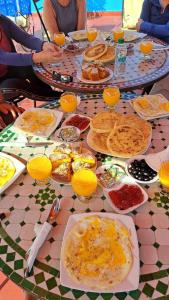 una tavola ricoperta di piatti di cibo e succo d'arancia di Dar Rita a Rabat