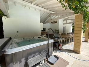 a hot tub in a patio with a table and chairs at Manoir et Appartements avec piscine au Domaine de Bize Mirepoix in Mirepoix