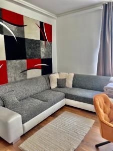 a living room with a couch and a painting at Azúr Port Siófok Balaton in Siófok