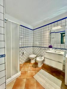 a bathroom with a toilet and a sink and a shower at Jennas-Libeccio Apartment in Àrbatax