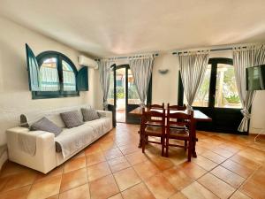 a living room with a couch and a table at Jennas-Libeccio Apartment in Àrbatax
