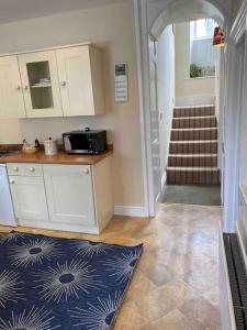 eine Küche mit einer Theke und eine Treppe mit einem Teppich in der Unterkunft Rokeby House, Reeth in Reeth