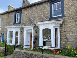 a brick house with white doors and windows at Reeth, Yorkshire, walking & cycling routes in Reeth