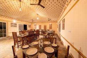 une salle à manger avec des tables et des chaises et un plafond dans l'établissement Tiger Machan, à Sawai Madhopur